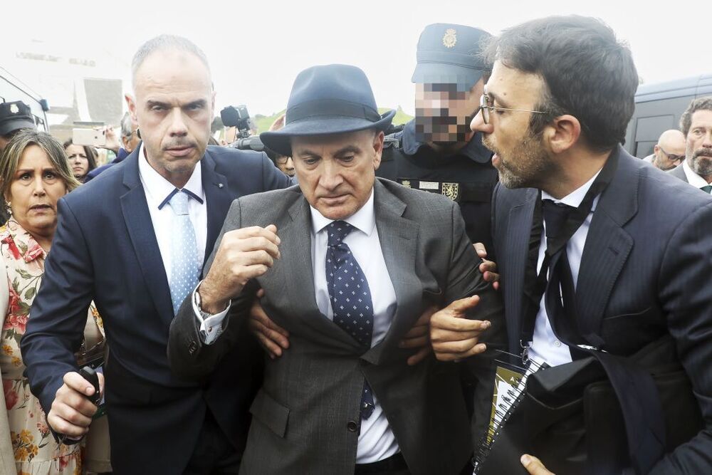 El ex jefe de Seguridad de Adif, Andrés Cortabitarte, es escoltado por la policía tras ser increpado y golpeado en el primer día de juicio