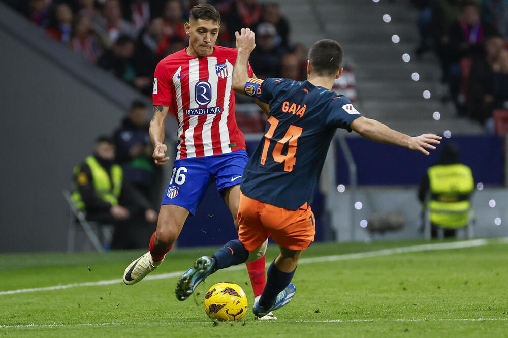 El defensa del Atlético de Madrid Nahuel Molina (i) disputa un balón ante José Luis Gayá, defensa del Valencia